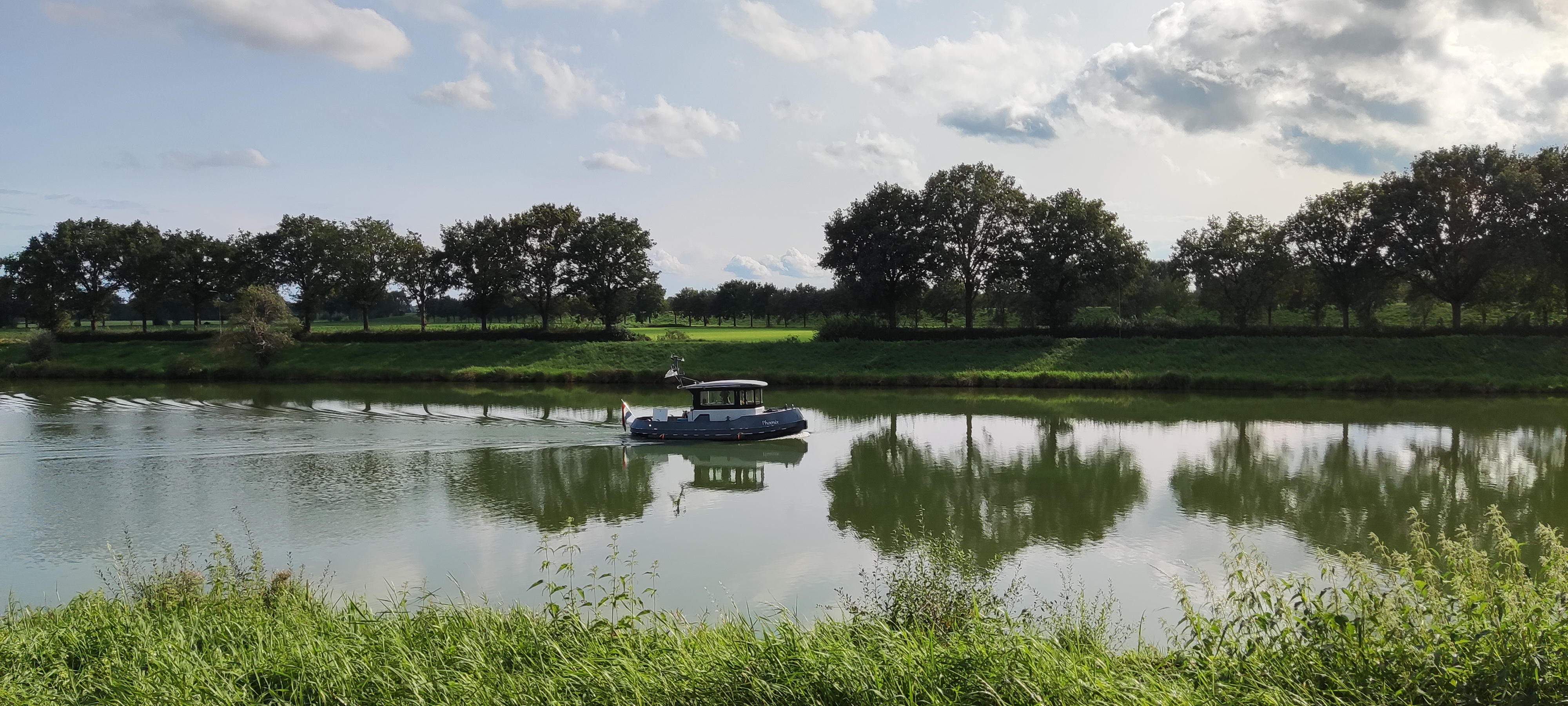 Foto van de Maas met een bootje erop. 