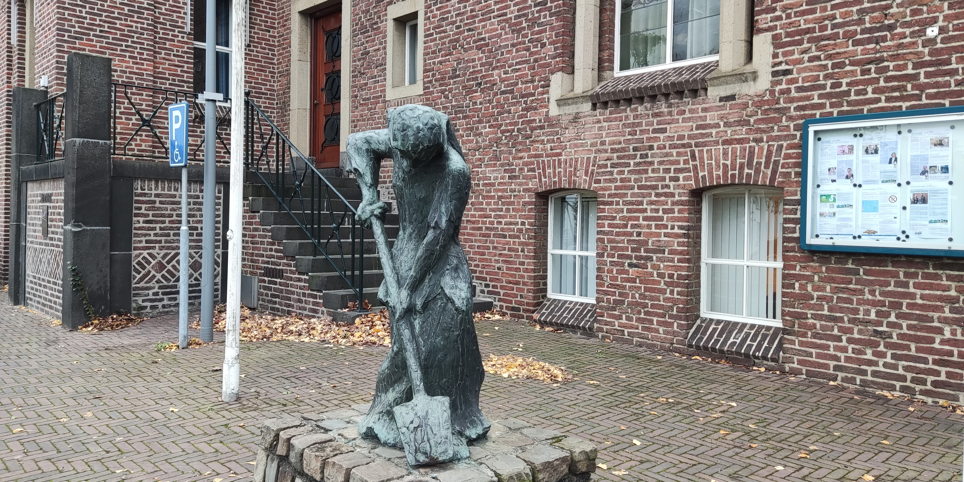 Standbeeld van Kiste Trui met het gemeentehuis op de achtergrond